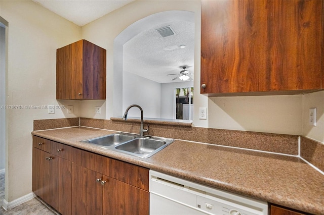 2252 NE 42nd Cir, Homestead, FL 33033 - kitchen with a sink, white dishwasher, a textured ceiling, a ceiling fan, and brown cabinetry
