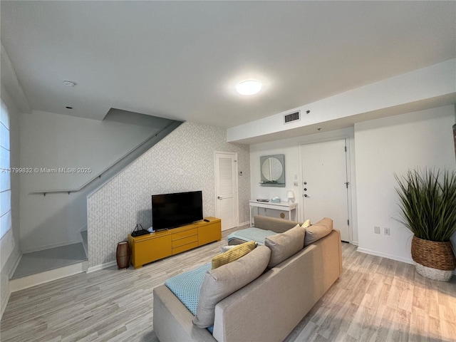 1614 Pennsylvania Ave Unit 2I, Miami Beach, FL 33139 - living room with light wood finished floors, baseboards, wallpapered walls, and stairway