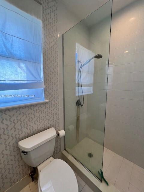 1614 Pennsylvania Ave Unit 2I, Miami Beach, FL 33139 - full bath with tiled shower, tile patterned floors, toilet, and wallpapered walls