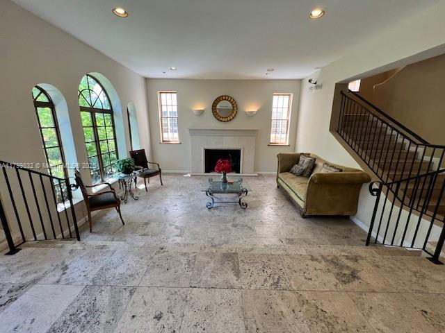 1614 Pennsylvania Ave Unit 2I, Miami Beach, FL 33139 - living room with healthy amount of natural light, recessed lighting, stairs, baseboards, and a fireplace