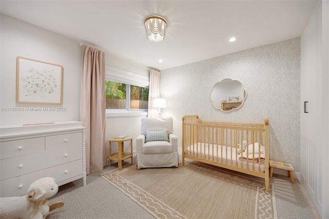 carpeted bedroom with a crib and recessed lighting