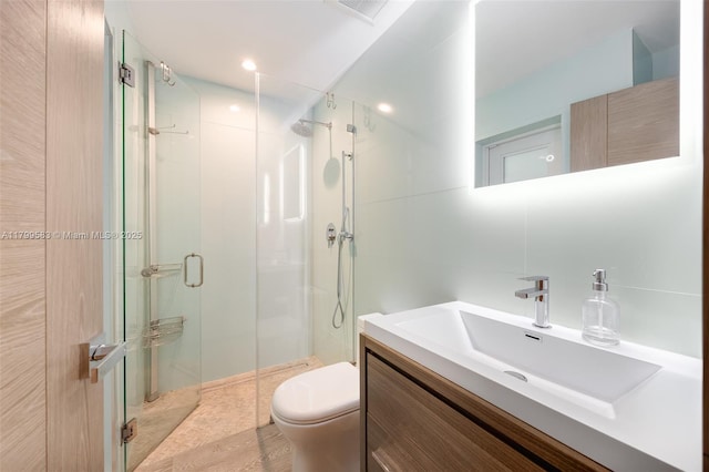 bathroom featuring toilet, a stall shower, and vanity