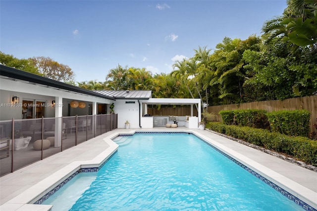 view of swimming pool with outdoor lounge area, fence, and a patio area