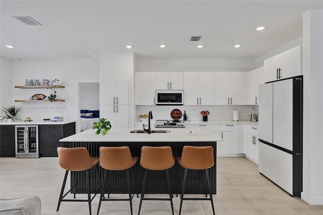 14836 SW 162nd St, Miami, FL 33187 - kitchen with beverage cooler, white appliances, light countertops, a breakfast bar area, and white cabinetry