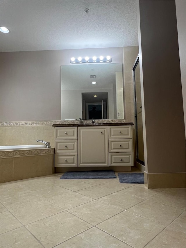 37 E Harbour Isle Dr E Unit 206, Fort Pierce, FL 34949 - bathroom with tile patterned floors, a stall shower, vanity, a bath, and a textured ceiling