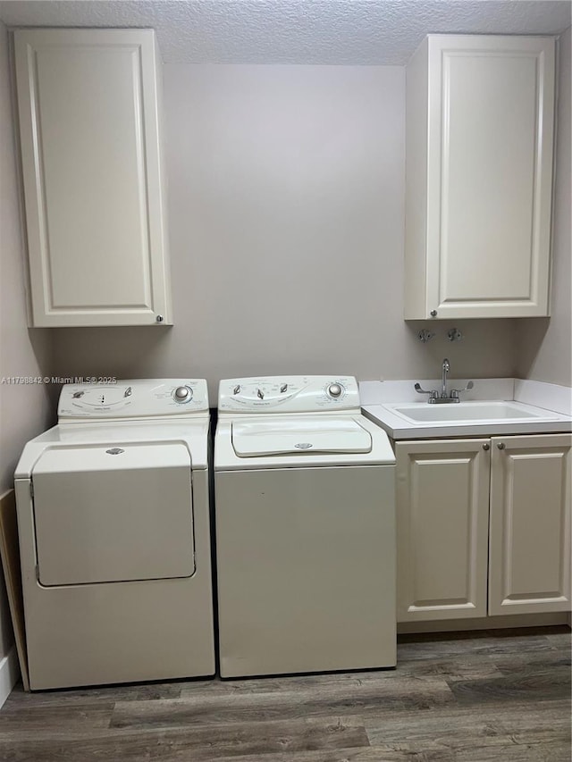 37 E Harbour Isle Dr E Unit 206, Fort Pierce, FL 34949 - laundry room featuring washing machine and clothes dryer, cabinet space, dark wood finished floors, and a textured ceiling