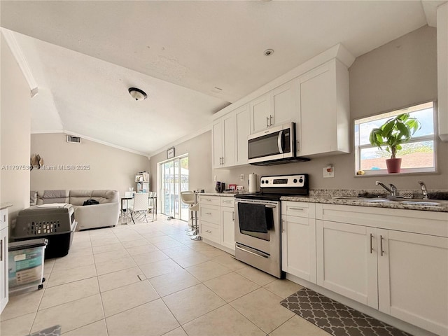 5730 NW 199th St, Hialeah, FL 33015 - kitchen featuring stainless steel appliances, a sink, vaulted ceiling, open floor plan, and crown molding
