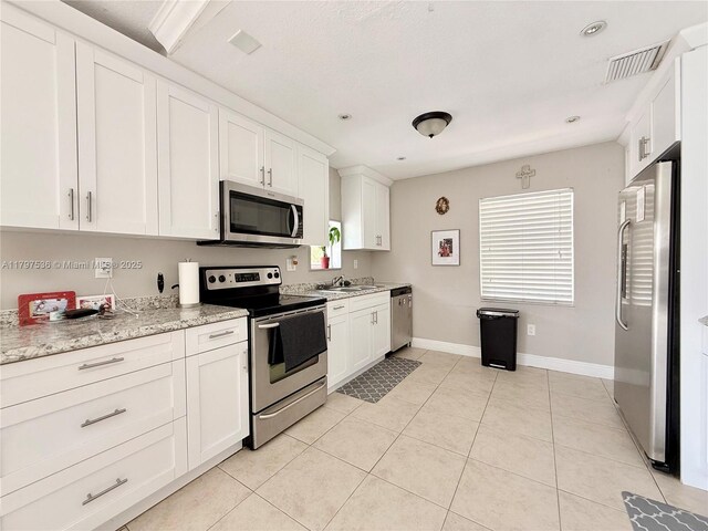 5730 NW 199th St, Hialeah, FL 33015 - kitchen featuring appliances with stainless steel finishes, a sink, baseboards, and white cabinets