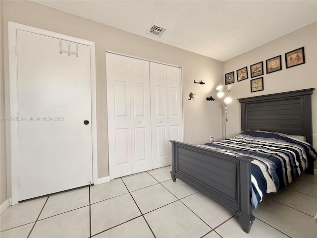 5730 NW 199th St, Hialeah, FL 33015 - bedroom featuring a closet, light tile patterned flooring, a textured ceiling, and baseboards