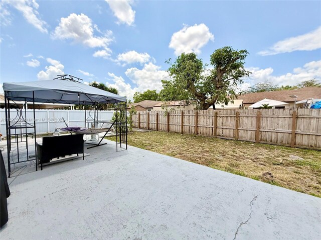 5730 NW 199th St, Hialeah, FL 33015 - view of patio / terrace with a gazebo, an outdoor fire pit, and a fenced backyard