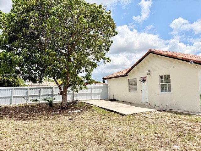 5730 NW 199th St, Hialeah, FL 33015 - back of property featuring a tiled roof, fence, a patio, and stucco siding