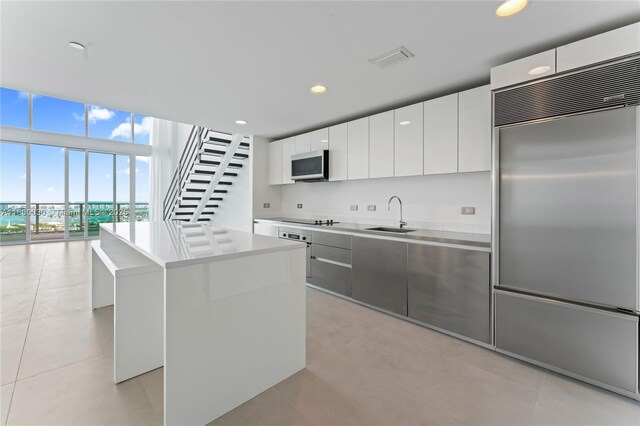 1040 Biscayne Blvd Unit 3802, Miami, FL 33132 - kitchen featuring stainless steel appliances, a sink, a kitchen island, modern cabinets, and white cabinetry