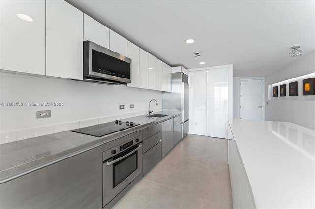 1040 Biscayne Blvd Unit 3802, Miami, FL 33132 - kitchen featuring stainless steel appliances, modern cabinets, white cabinets, a sink, and recessed lighting