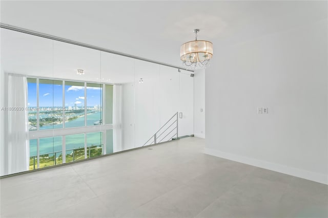 1040 Biscayne Blvd Unit 3802, Miami, FL 33132 - spare room featuring floor to ceiling windows, a water view, a chandelier, and baseboards