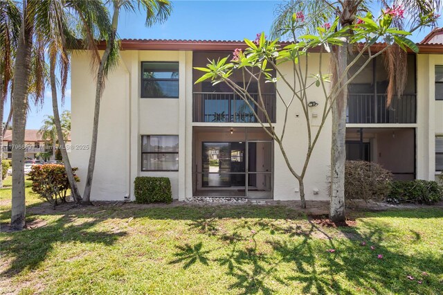 22053 Palms Way Unit 106, Boca Raton, FL 33433 - back of house featuring stucco siding and a yard