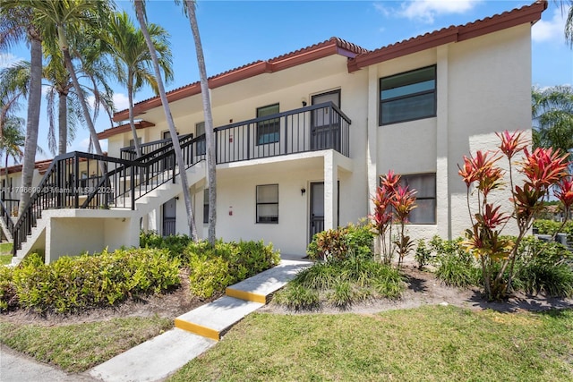 22053 Palms Way Unit 106, Boca Raton, FL 33433 - view of front of house with stairway, stucco siding, a tiled roof, and a front yard