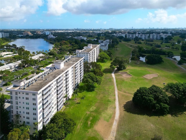drone / aerial view of a nearby body of water, apartment complex, and a local golf course