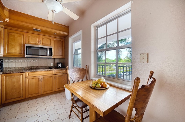 dining area with a ceiling fan and a textured wall