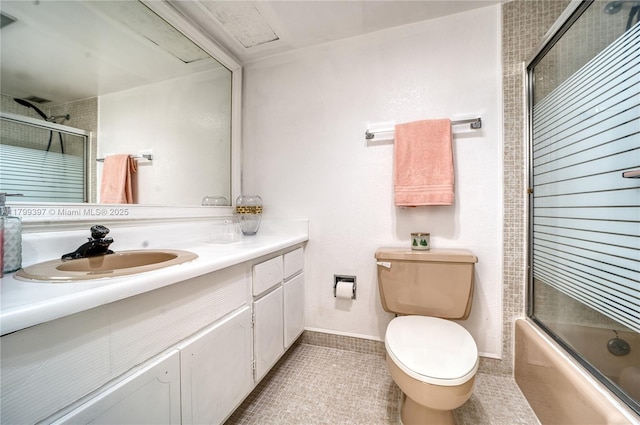 full bath featuring toilet, vanity, tile patterned floors, shower / bath combination with glass door, and baseboards