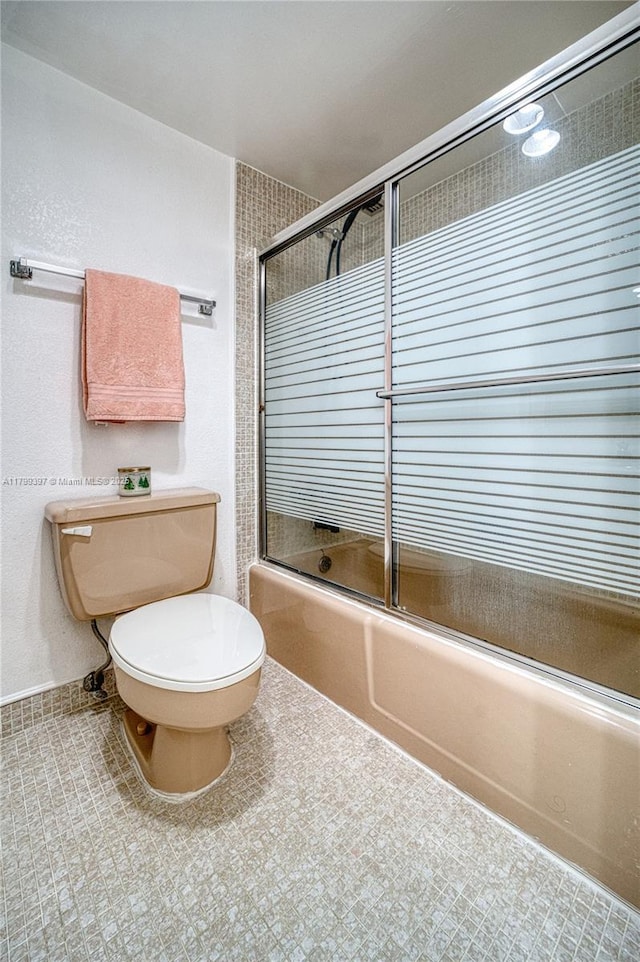 bathroom with bath / shower combo with glass door and toilet