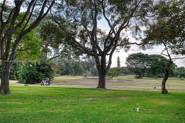 view of home's community with a lawn and view of wooded area