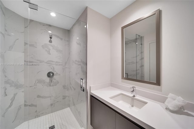 full bathroom with a marble finish shower, vanity, and recessed lighting