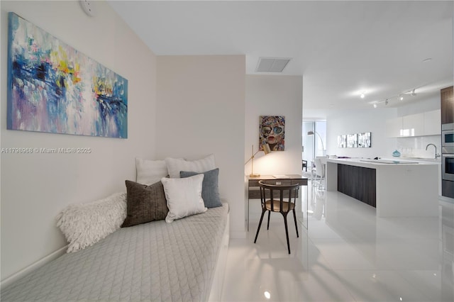 living room featuring track lighting, baseboards, and light tile patterned floors