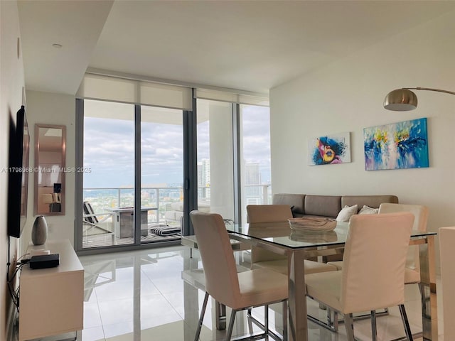 dining area with plenty of natural light, light tile patterned flooring, and a wall of windows