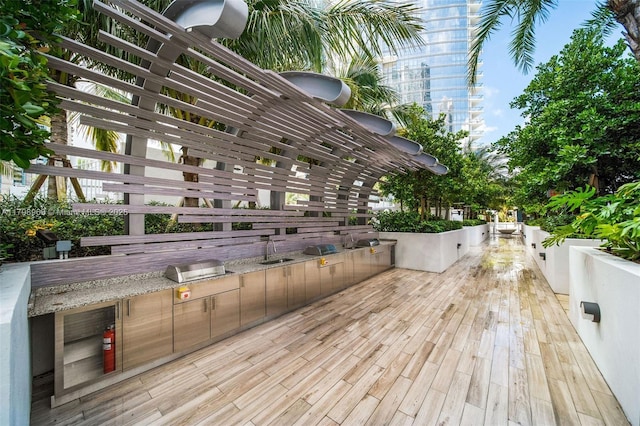 deck with an outdoor kitchen and a sink