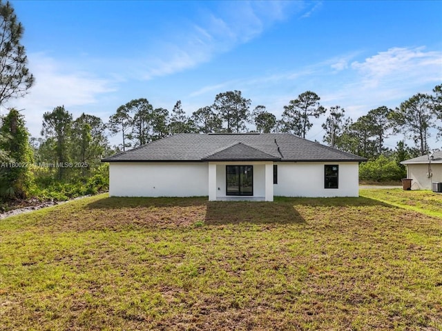 631 S Summit Ave, Lehigh Acres, FL 33974 - back of property featuring a lawn, central AC, and stucco siding