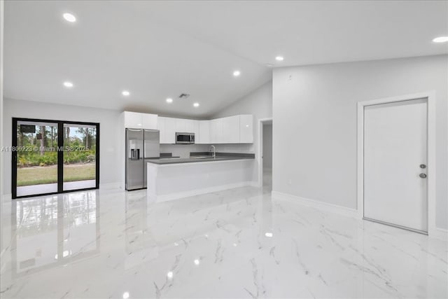 kitchen featuring appliances with stainless steel finishes, dark countertops, white cabinets, a sink, and recessed lighting