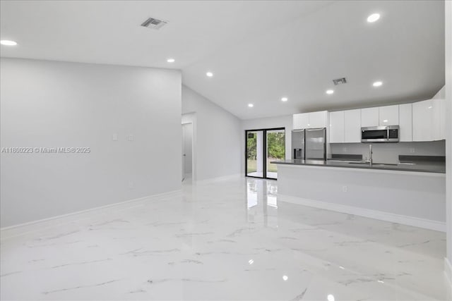 kitchen featuring appliances with stainless steel finishes, dark countertops, baseboards, white cabinetry, and recessed lighting