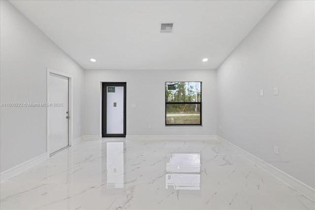 spare room featuring light marble finish flooring, recessed lighting, and baseboards