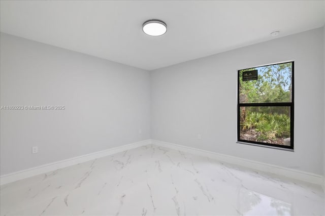 empty room with marble look tiles and baseboards