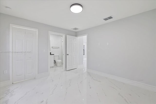 631 S Summit Ave, Lehigh Acres, FL 33974 - unfurnished bedroom with baseboards, marble finish floors, and connected bathroom