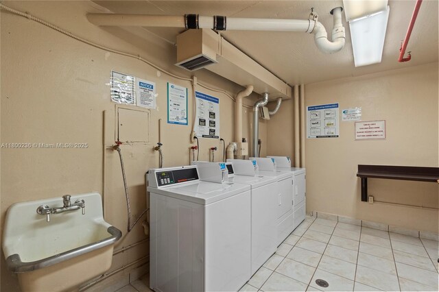 5701 Collins Ave Unit 917, Miami Beach, FL 33140 - communal laundry room with washing machine and clothes dryer and light tile patterned floors