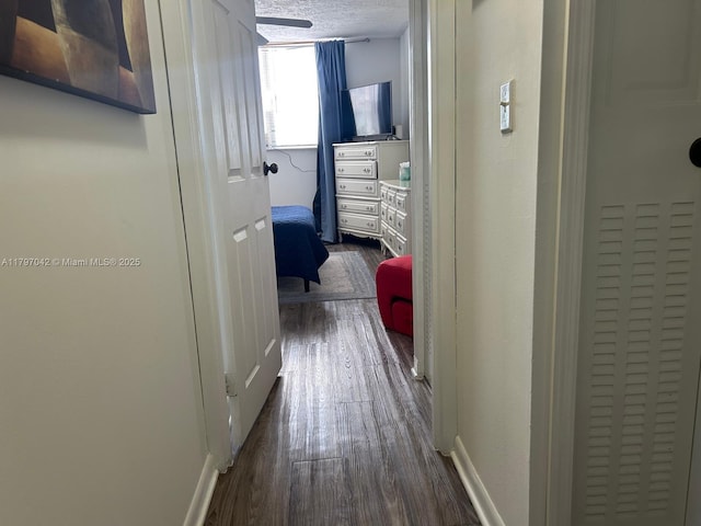 2851 Somerset Dr Unit 307, Lauderdale Lakes, FL 33311 - hall featuring dark wood finished floors, a textured ceiling, and baseboards
