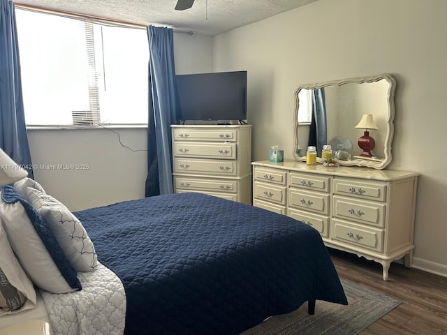 2851 Somerset Dr Unit 307, Lauderdale Lakes, FL 33311 - bedroom with multiple windows, dark wood-style flooring, a textured ceiling, a ceiling fan, and baseboards