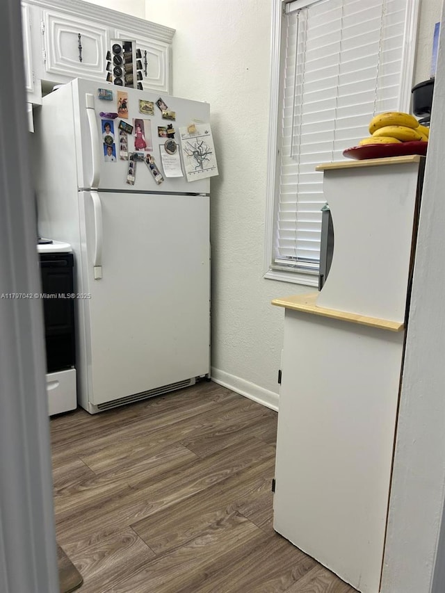 2851 Somerset Dr Unit 307, Lauderdale Lakes, FL 33311 - kitchen with freestanding refrigerator, wood finished floors, electric range, and white cabinets