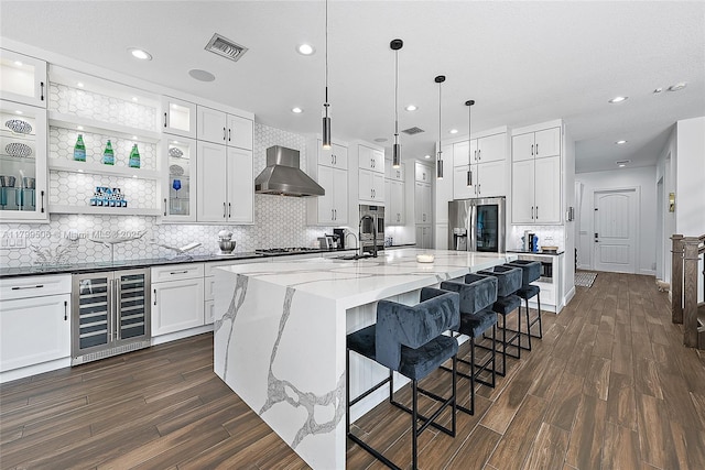 2069 Dickens Ter, Palm Beach Gardens, FL 33418 - kitchen featuring wine cooler, stainless steel fridge with ice dispenser, wall chimney range hood, dark wood finished floors, and tasteful backsplash