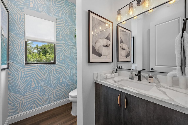 2069 Dickens Ter, Palm Beach Gardens, FL 33418 - bathroom with wallpapered walls, wood finished floors, toilet, vanity, and baseboards