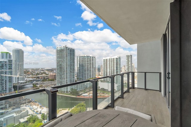 balcony featuring a view of city and a water view