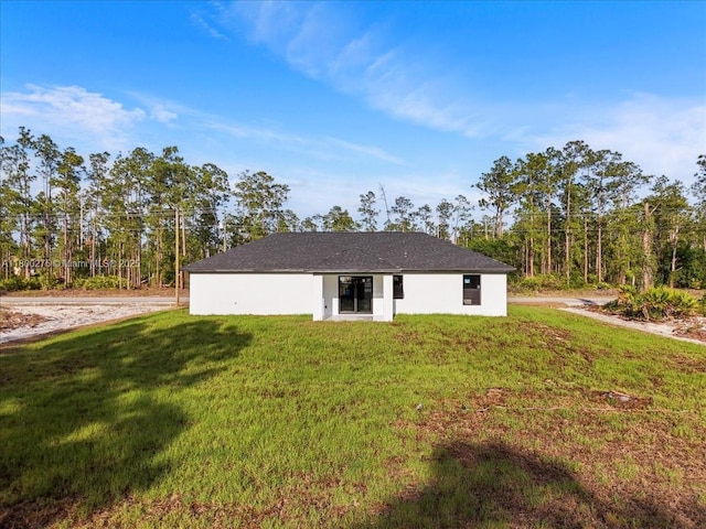 817 Moore Ave, Lehigh Acres, FL 33972 - rear view of property with a yard and stucco siding