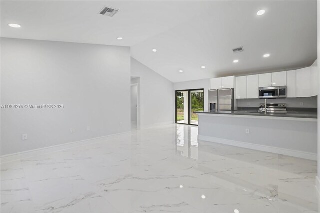 817 Moore Ave, Lehigh Acres, FL 33972 - kitchen with stainless steel appliances, open floor plan, dark countertops, light marble finish floors, and recessed lighting