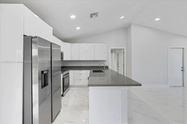 817 Moore Ave, Lehigh Acres, FL 33972 - kitchen featuring stainless steel appliances, a sink, lofted ceiling, dark countertops, and light marble finish floors