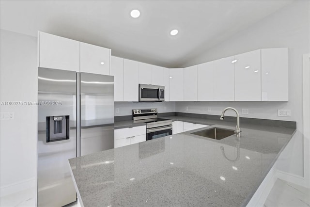 817 Moore Ave, Lehigh Acres, FL 33972 - kitchen with stainless steel appliances, a sink, white cabinets, a peninsula, and modern cabinets