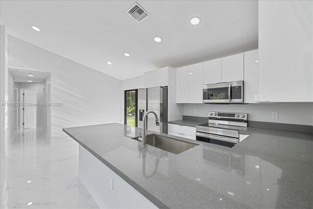 817 Moore Ave, Lehigh Acres, FL 33972 - kitchen featuring stainless steel appliances, light marble finish flooring, recessed lighting, white cabinets, and a sink