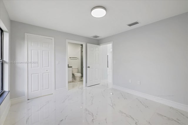 817 Moore Ave, Lehigh Acres, FL 33972 - unfurnished bedroom featuring baseboards, marble finish flooring, connected bathroom, and a closet