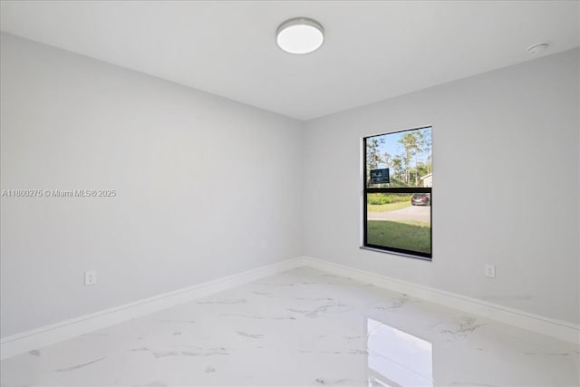 817 Moore Ave, Lehigh Acres, FL 33972 - empty room featuring marble look tile flooring, baseboards, and a smoke detector
