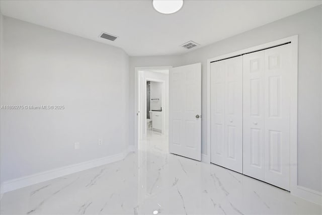 817 Moore Ave, Lehigh Acres, FL 33972 - unfurnished bedroom with baseboards, light marble finish floors, and a closet